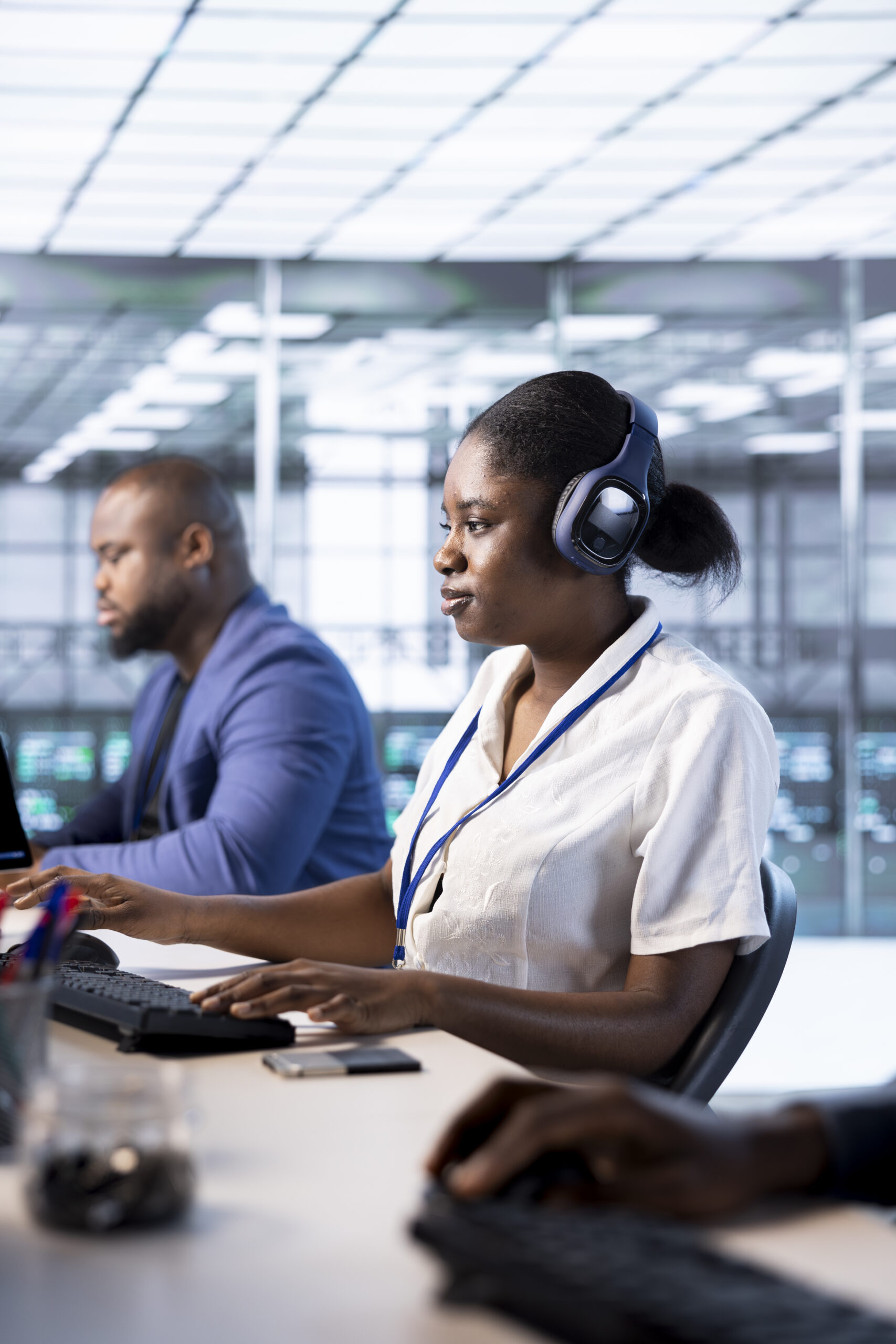 Woman in data center wearing headphones, running system diagnostic tests on PC. Worker listening music, deploying and error checking utilities on computer to fix network issues performance